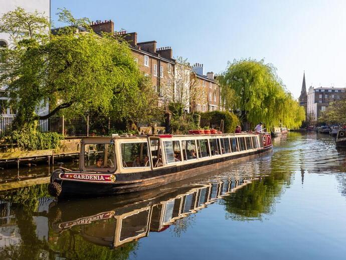 A canal boat moving down Regent's Canal in north London.