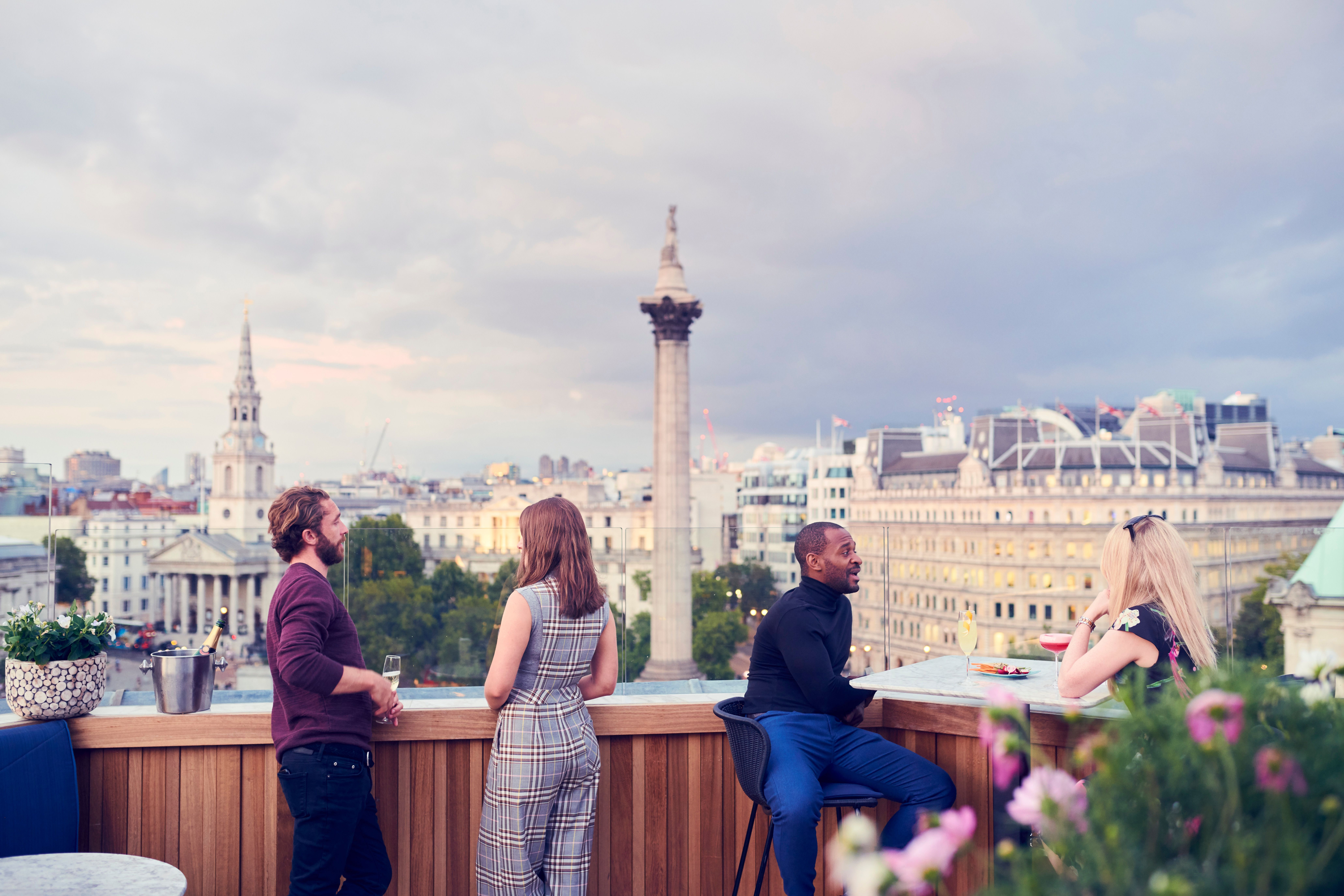 People having a drink at a rooftop bar in a city