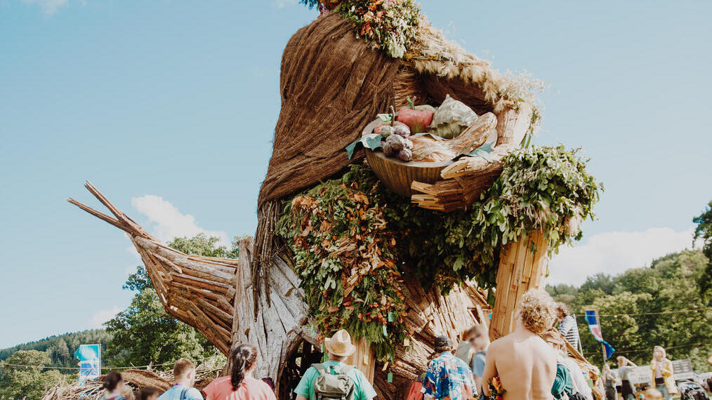 Group of people standing around large sculpture at a festival