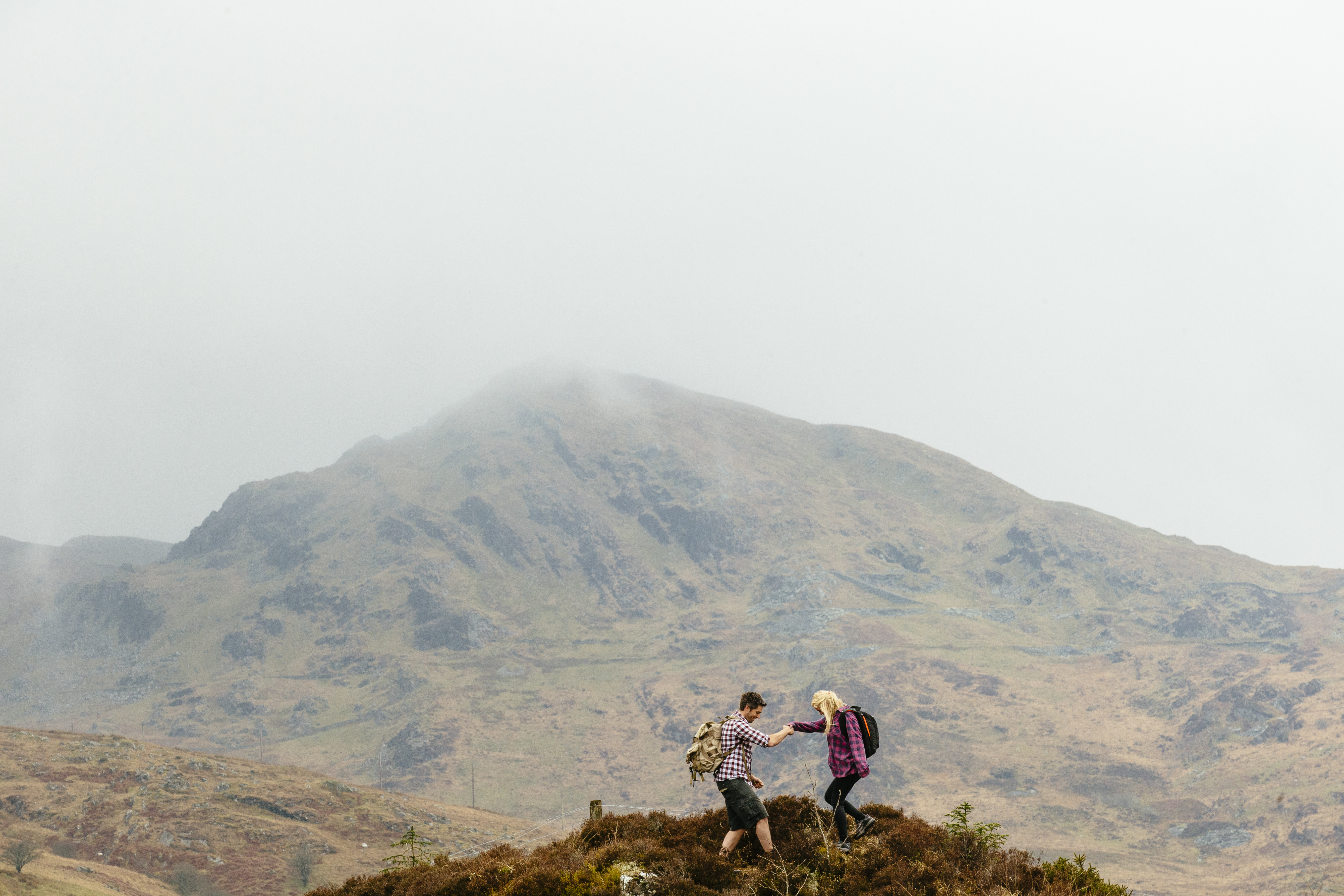 Couple hiking in the mountains on a cloudy day