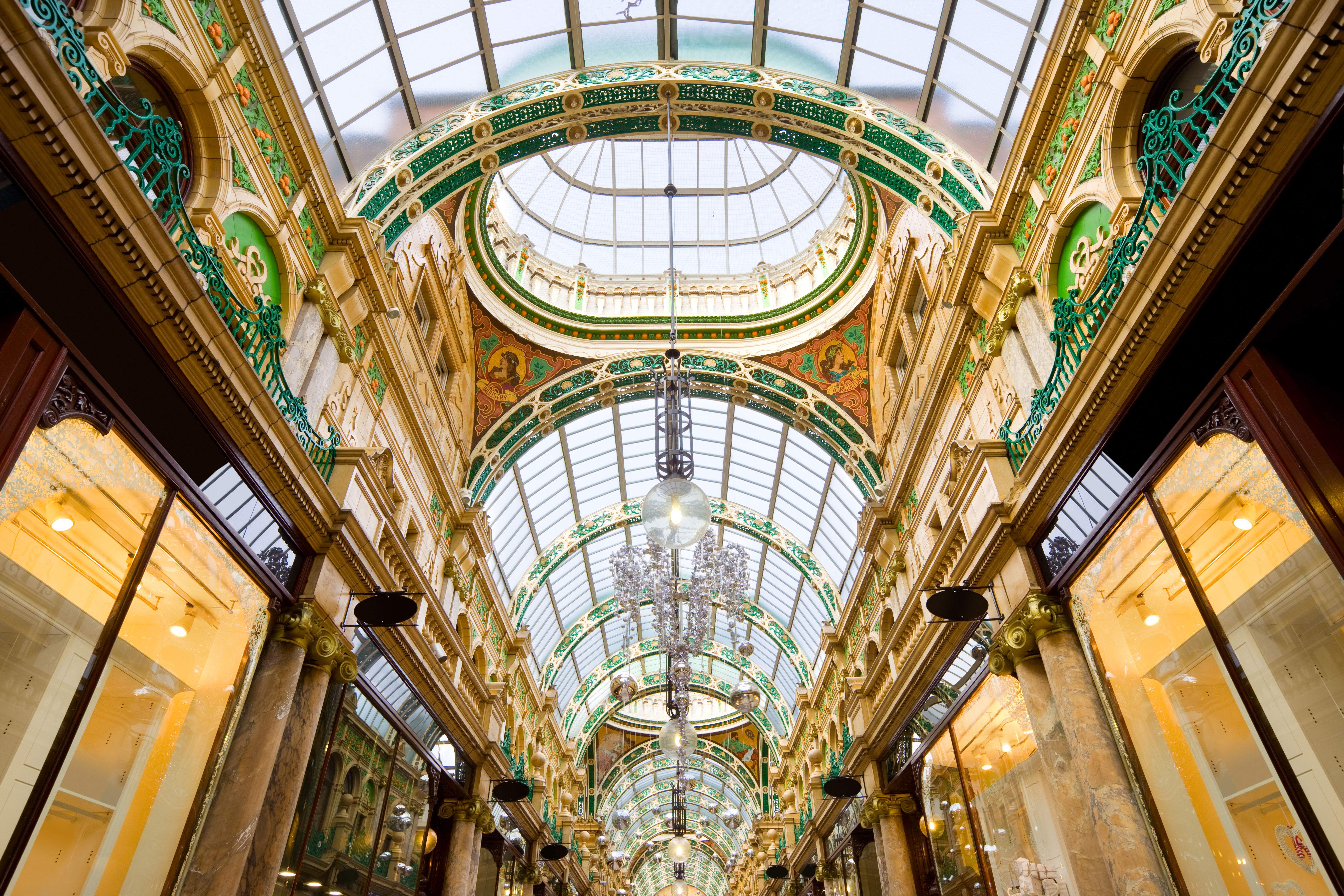 A majestic shopping arcade with ornate domed glass ceiling.