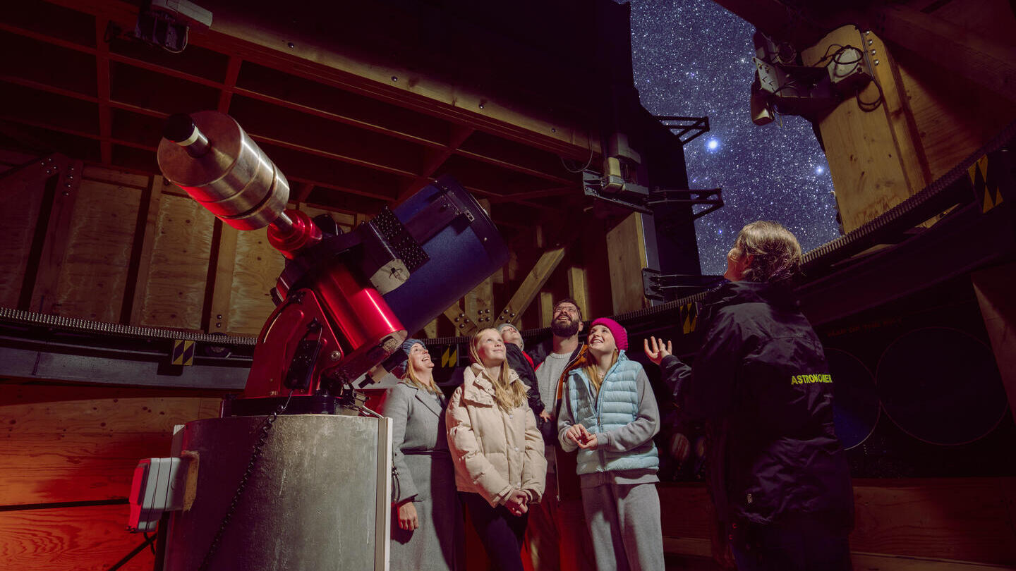 A family stand with a tour guide at an Observatory