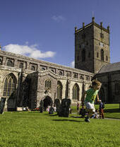 Ein Kind, das auf dem Gelände vor einer historischen Kirche herumrennt