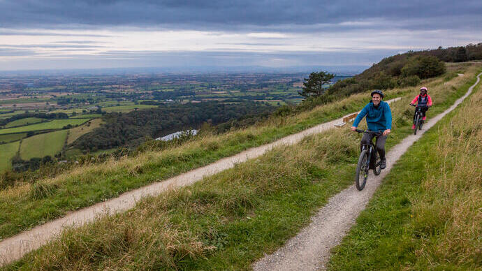 Un homme et une femme à vélo sur un sentier à flanc de colline
