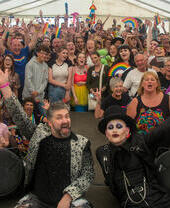 Group of people under a big tent, smiling and cheering