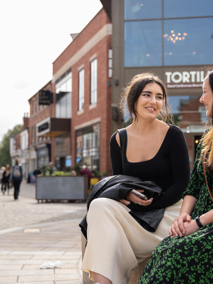 Two women sat on a bench in Lincoln's Cornhill Quarter