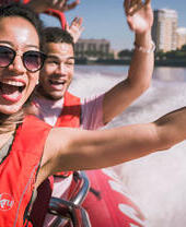 Close up of man young woman and man riding on speed boat on the Thames
