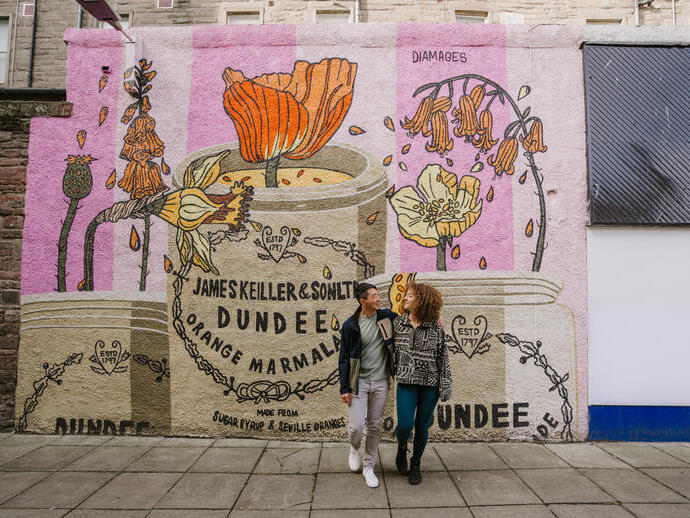 رجل وامرأة يتعانقان أمام جدارية المربى.