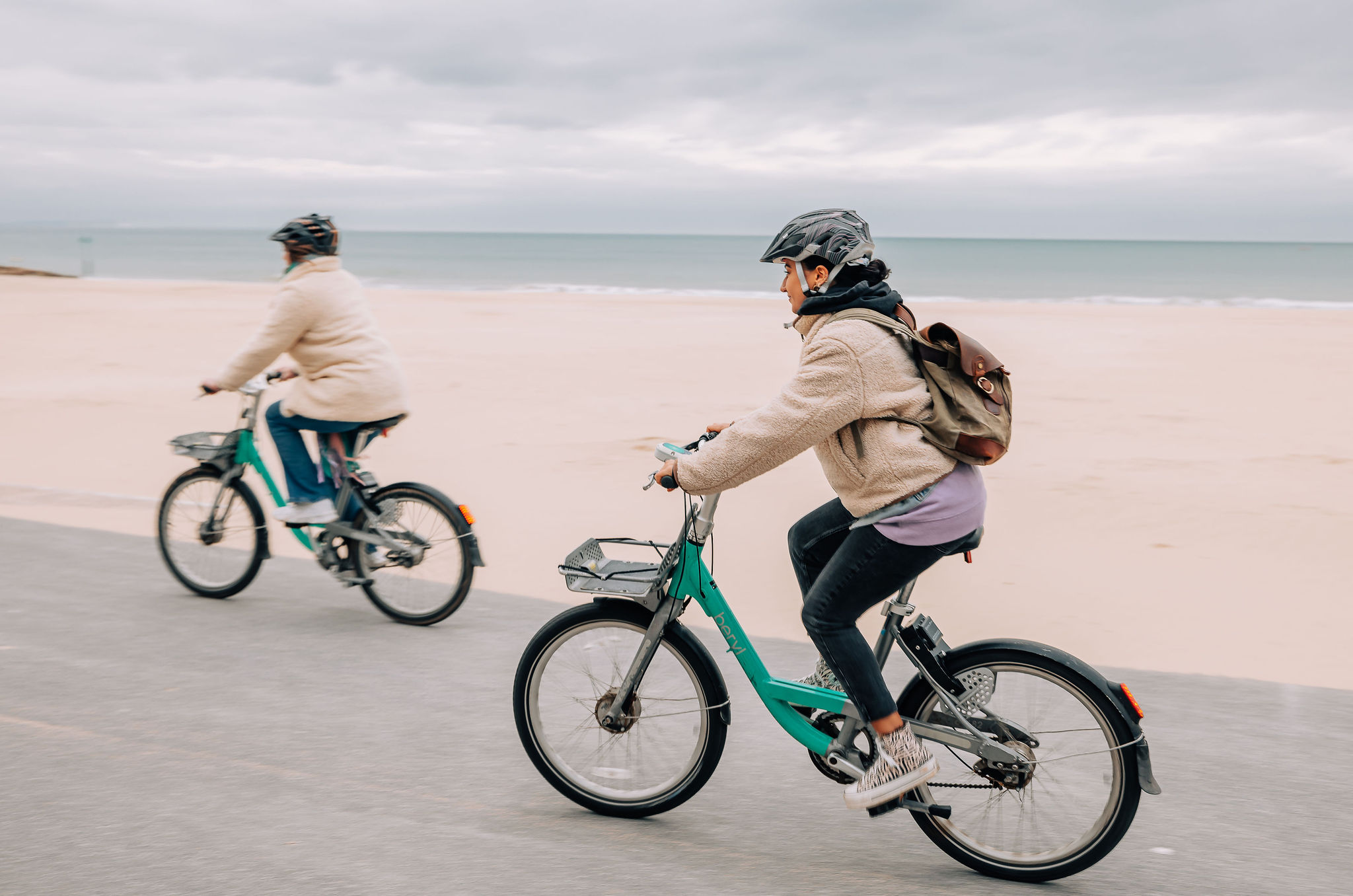 شخصان يركبان الدراجات على شاطئ بورنماوث.