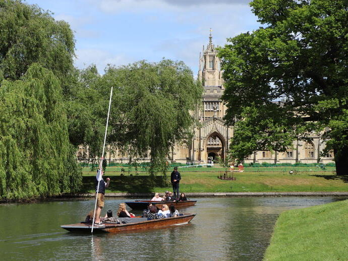 A punting tour passing a historic university building in Cambridge