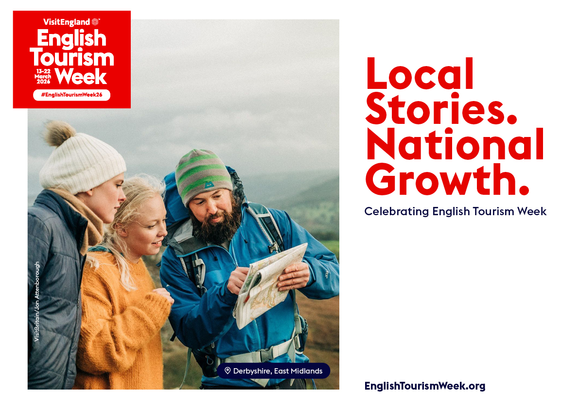 Three people in winter outdoor clothes look at a map together in the hills. Derbyshire, East Midlands. English Tourism Week banner.