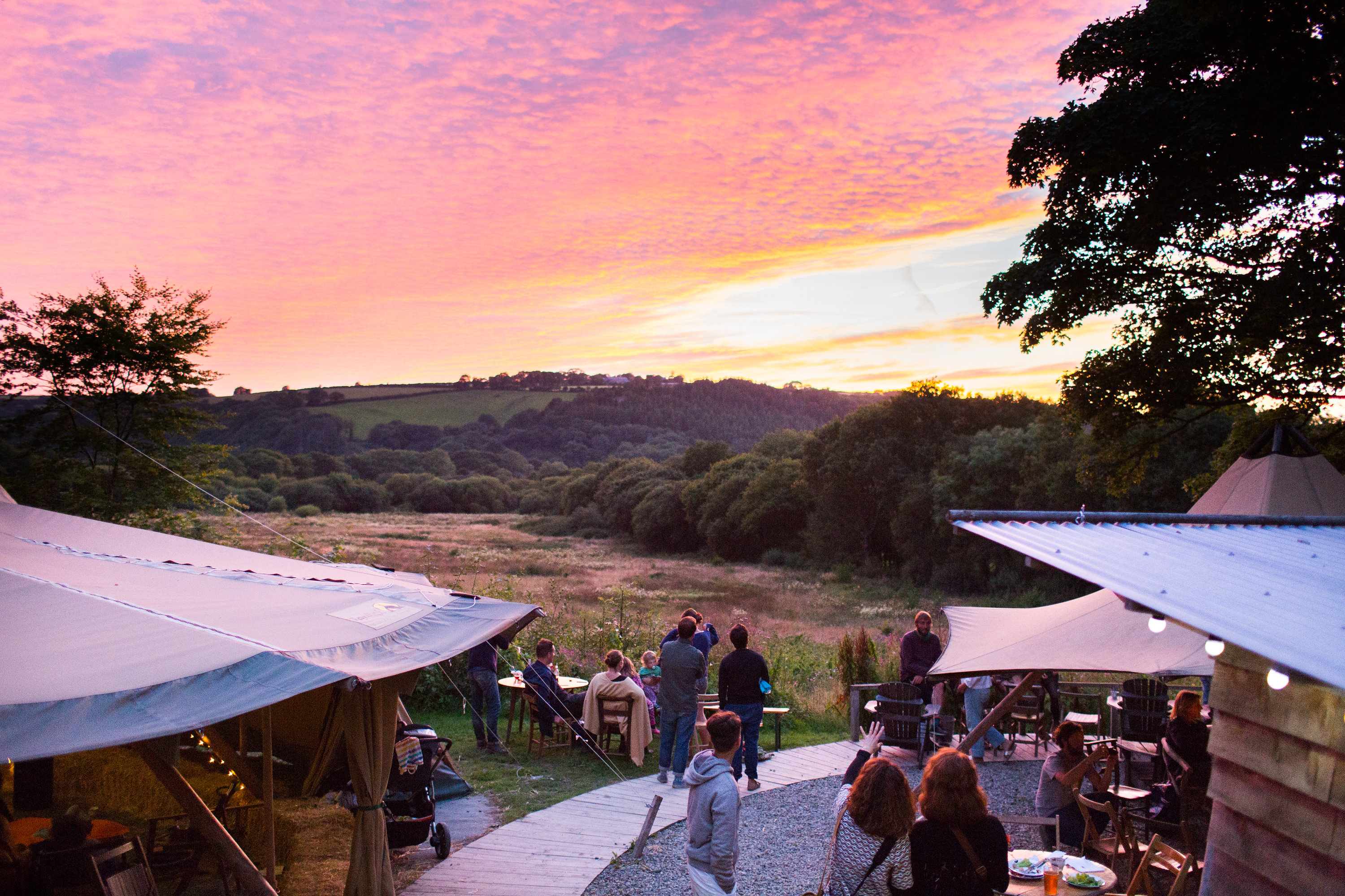 Groups of people watching the sunset at Fforest Farm