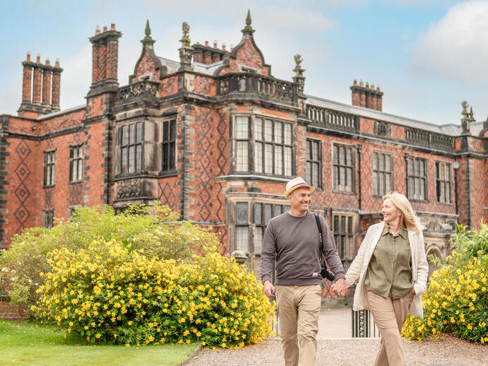 A man and a woman walk through the grounds of a heritage property