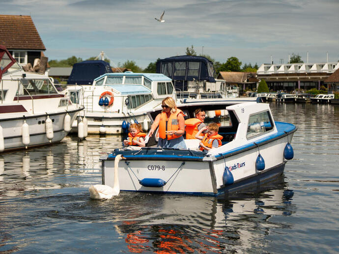 A family riding on a boat in the Norfolk Broads
