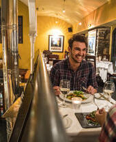 Man laughing whilst dining at restaurant