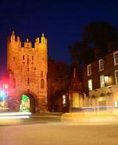 Tráfico pasando por Micklegate Bar al atardecer en York