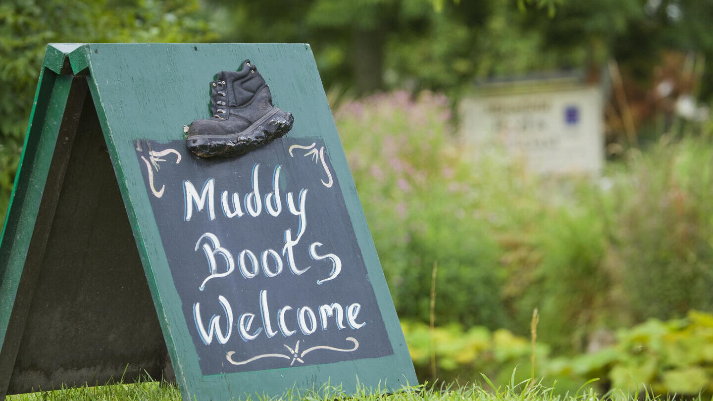 Board sign saying 'Muddy boots Welcome'