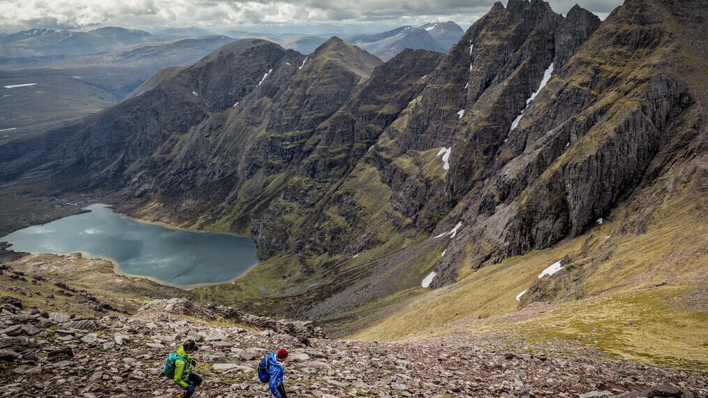 Des coureurs de trail descendant le flanc d'une montagne escarpée