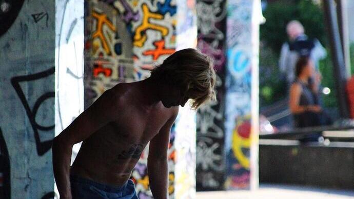 A man stood in front of grafitti art in London