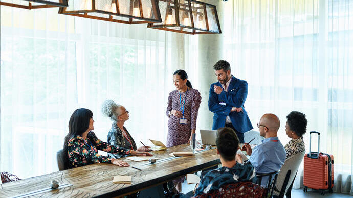 People having a meeting at a long table in a conference venue