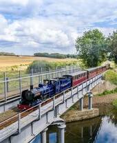 A steam train passing over a river in the Broads National Park