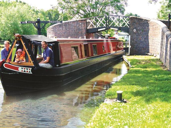 A family riding down a canal on a barge