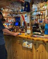 A man and woman looking at a bottle of whiskey at Pine Marten Bar