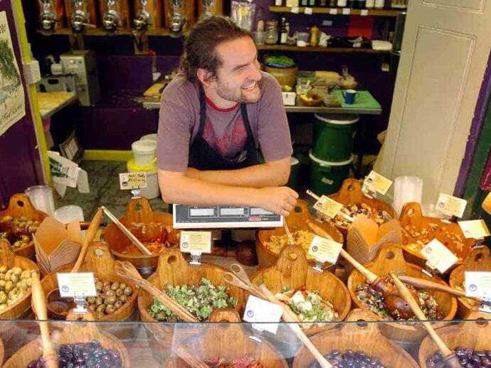 Un marchand vendant de nombreuses variétés d'olives sur son étal