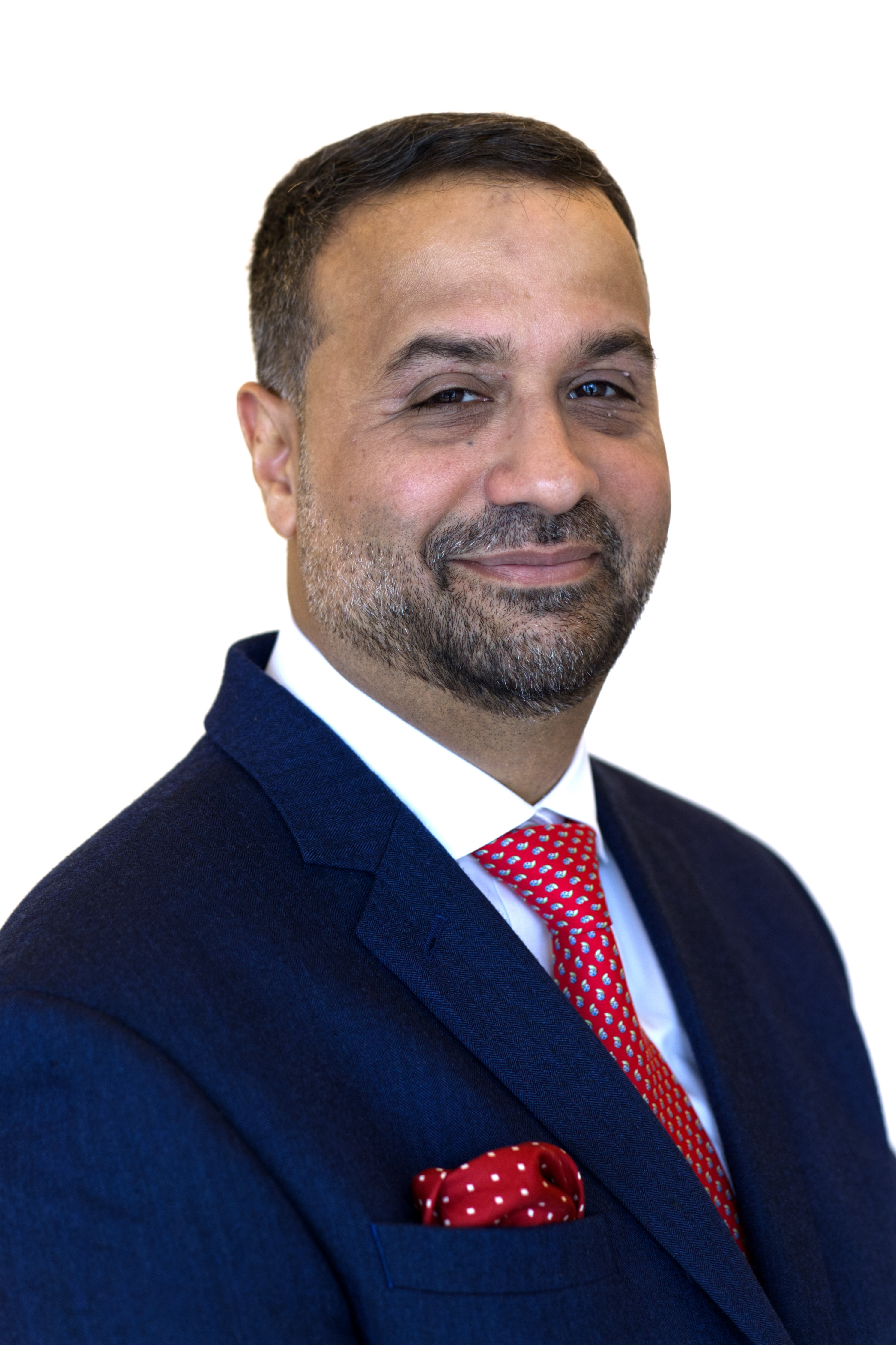 A person in a blue suit with a red tie and pocket square poses for a professional portrait against a plain white background.
