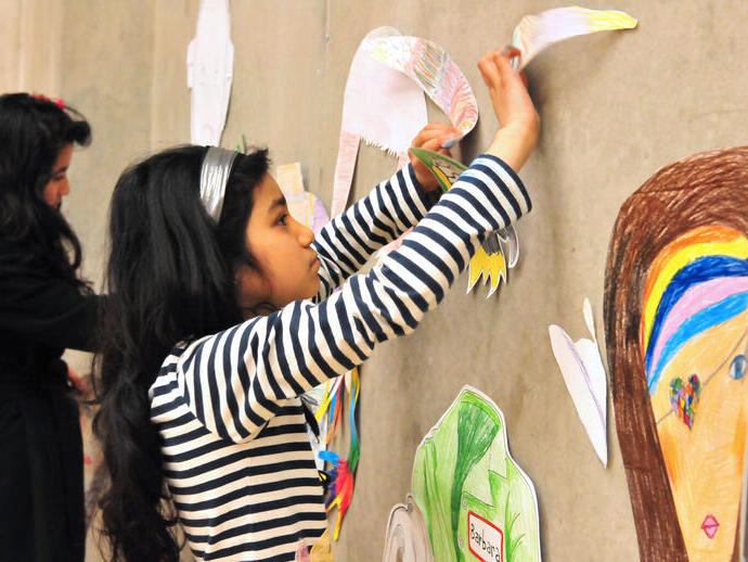 Un grupo de niños pegando dibujos en una pared en la Galería de Arte Contemporáneo de Nottingham