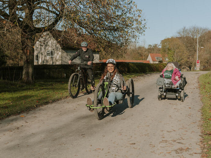 A woman using a hand bike with staff from the cycle hub