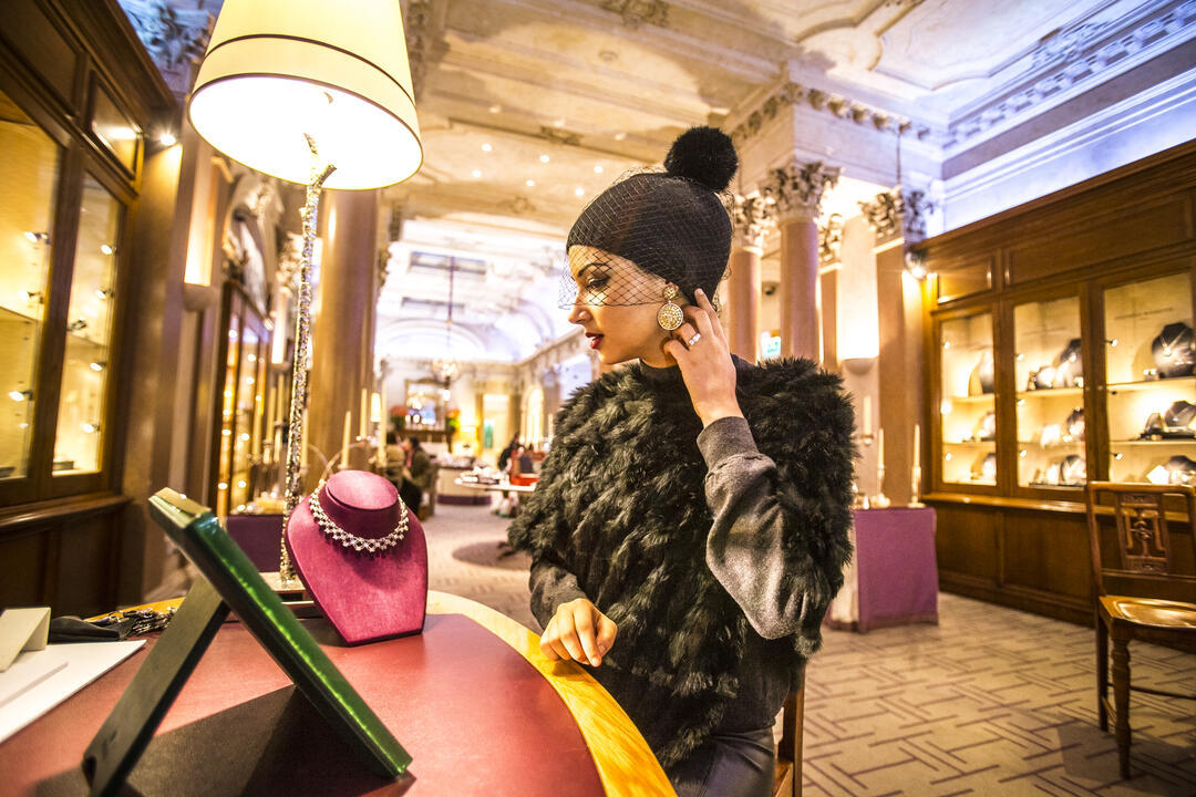 A young Arabic woman examining jewellery at Hamilton and Inches