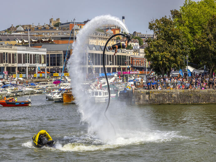 A man riding a jetstream of water into the air as part of Bristol Harbour Festival