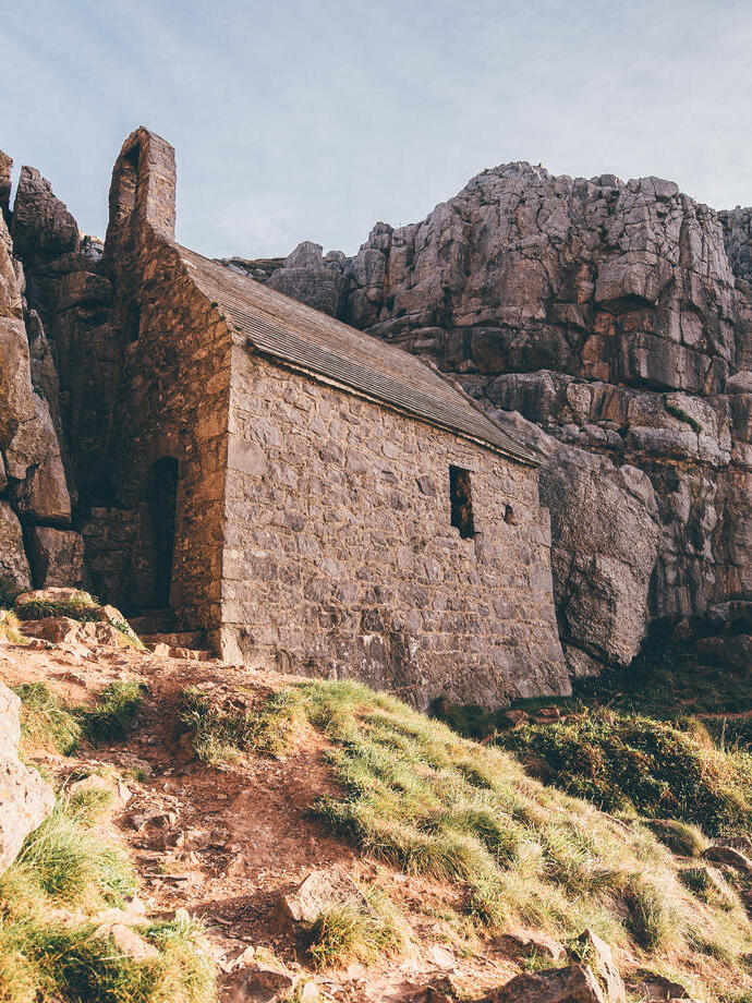 Un vecchio edificio in mattoni su una collina, circondato da scogliere.