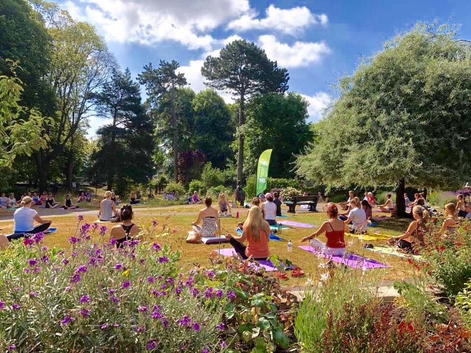 Groups of people taking a yoga session in a park on the Jurassic Coast