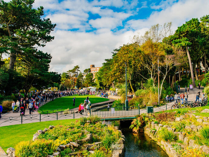 People walking in a park on a sunny day.