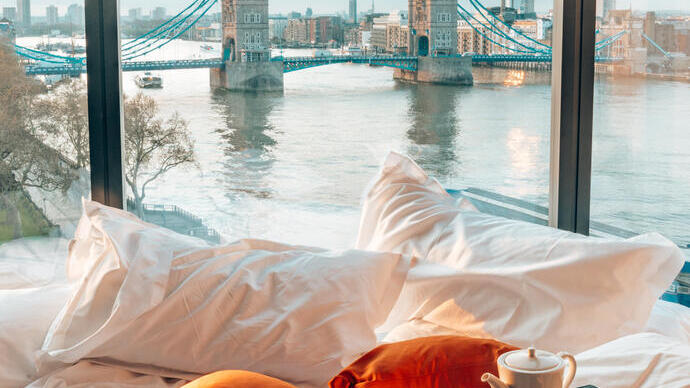 Een hotelkamer met uitzicht op de stad, een rivier en een brug vanuit het raam