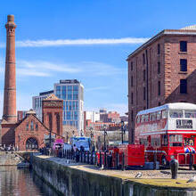 Dockside scene showing a double decker bus and industrial buildings beside a lock