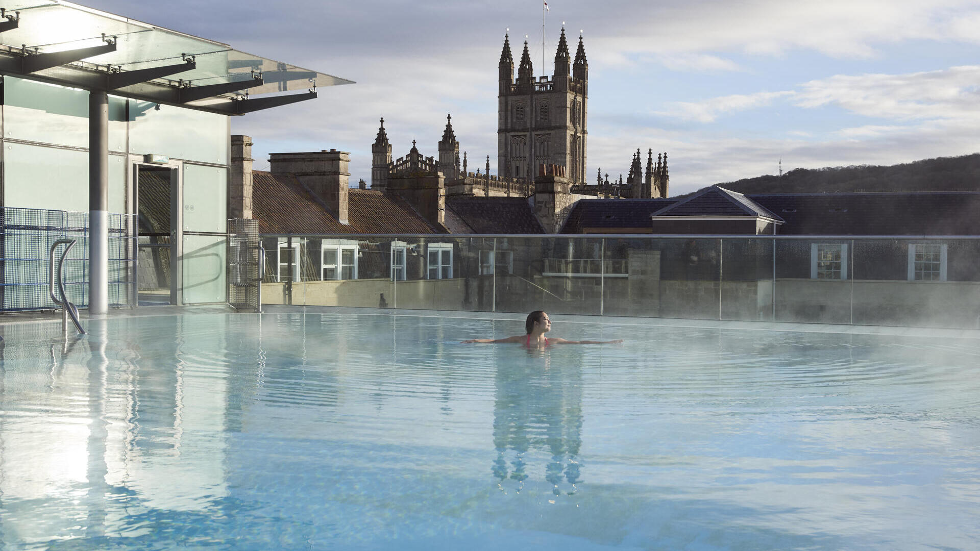 Woman in a roof top swimming pool at a spa