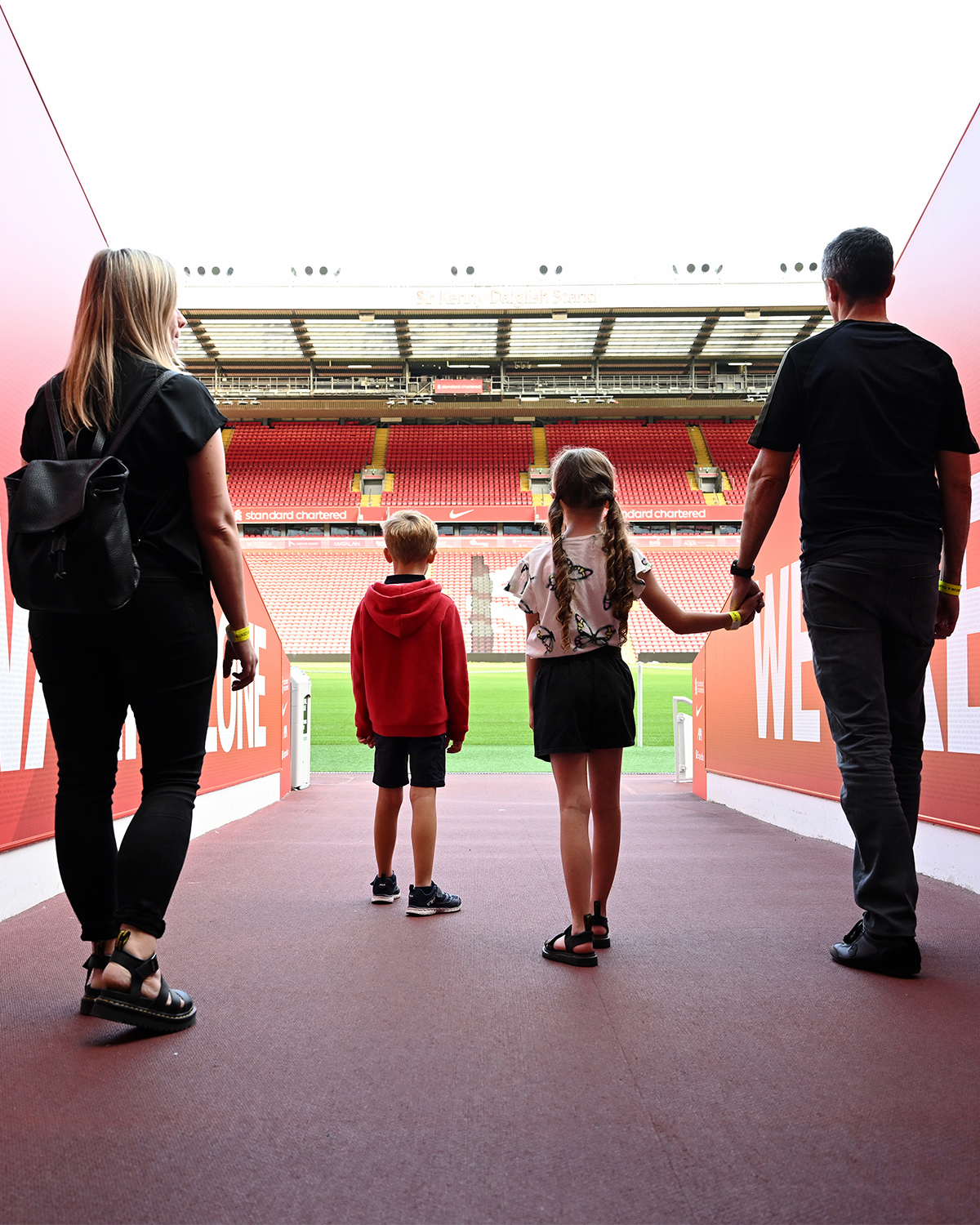A family walking through the Tunnel to view the pitch as part of the stadium tour.