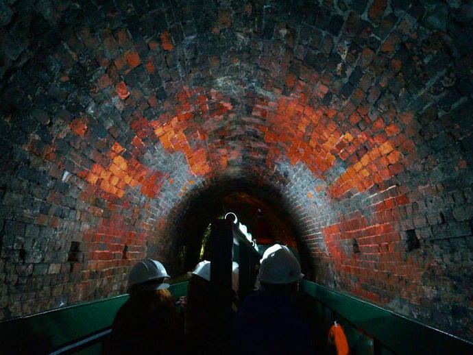 Un groupe de touristes guidé à travers un tunnel sous le canal de Dudley