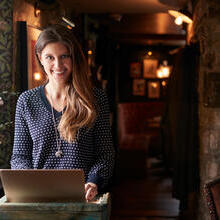 Woman working on laptop at a hotel check-in desk