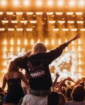 Girl sitting on the shoulders of a guy in the crowd at TRNSMT festival