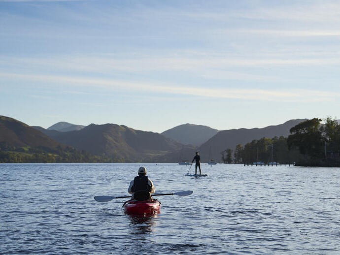 Kajakker en stand-up paddleboarder op een meer