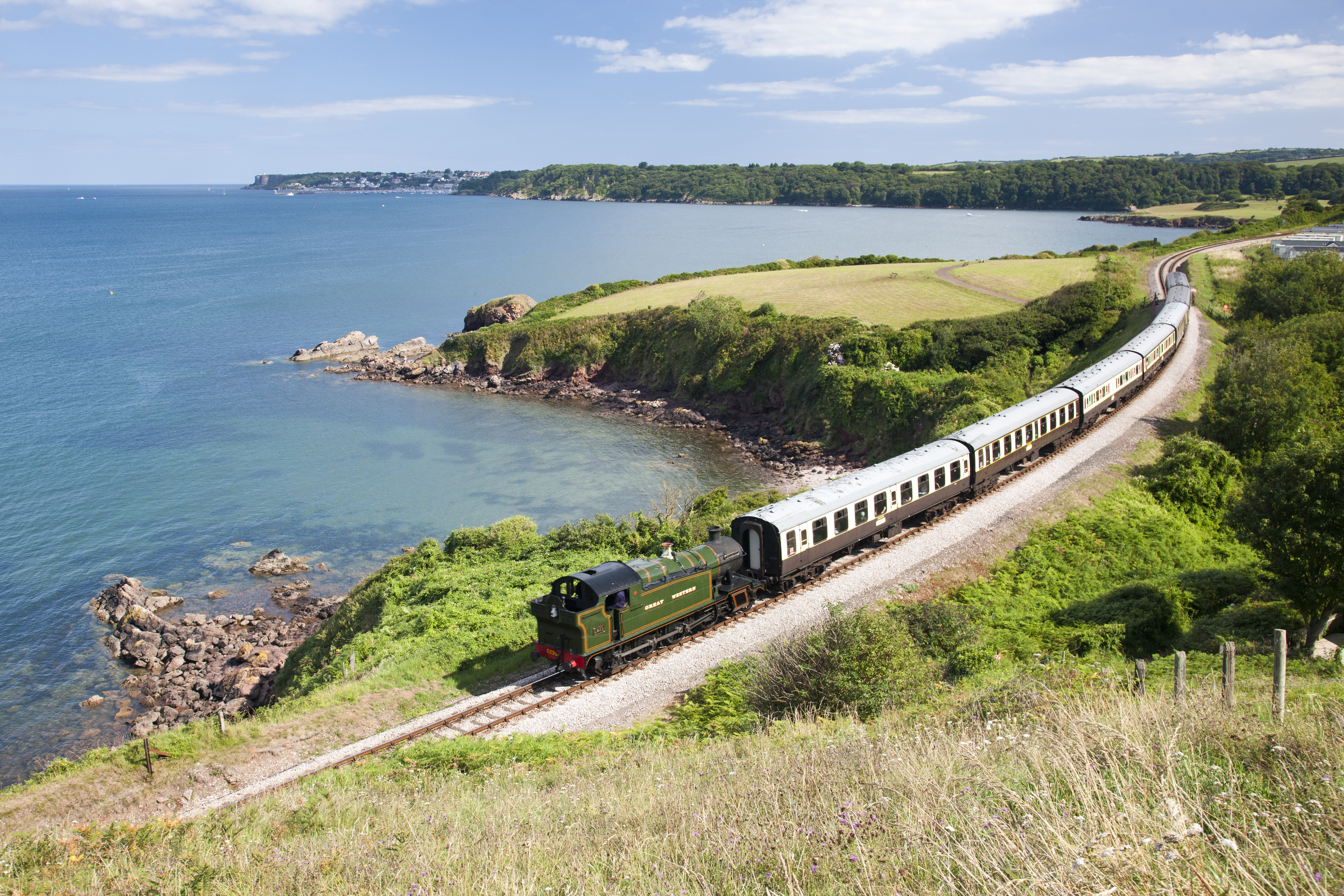 Steam train on a railway line following the coastline