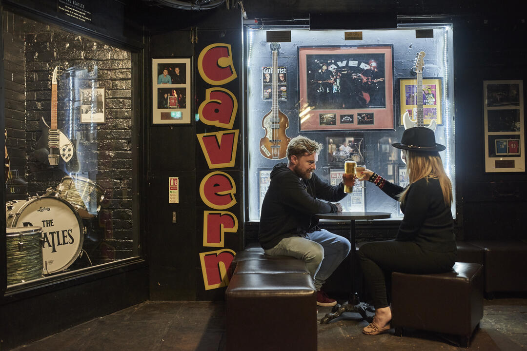 Hombre y mujer sentados en un club de música tomando una copa
