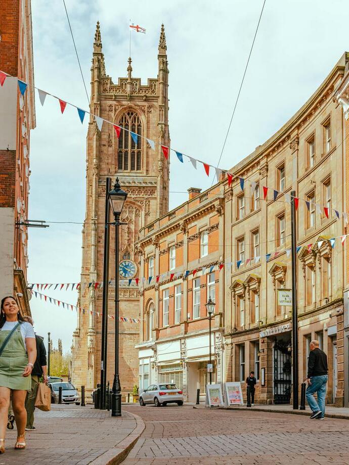 People walking down a street with a cathedral