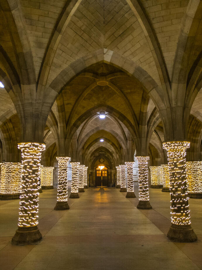 Fairy lights wrapped around pillars in a cloister