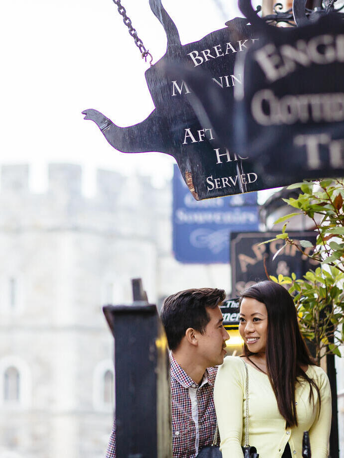 A Chinese couple entering a Windsor tea room to have cream tea. Antique signs.
