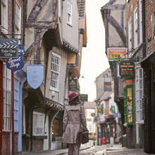 Woman walking through a narrow historic street in a city